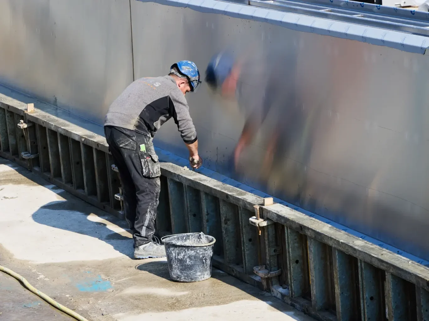 Arbeiter beim Verarbeiten von Beton an einer Baustelle.